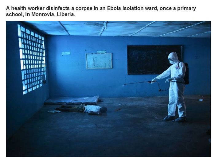 ebola isolation ward - A health worker disinfects a corpse in an Ebola isolation ward, once a primary school, in Monrovia, Liberia. Midt Juuni Binnen