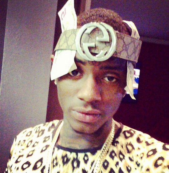 Between the belt on the head and the dollars stuck in it, we dont know whats going on with Soulja Boy.