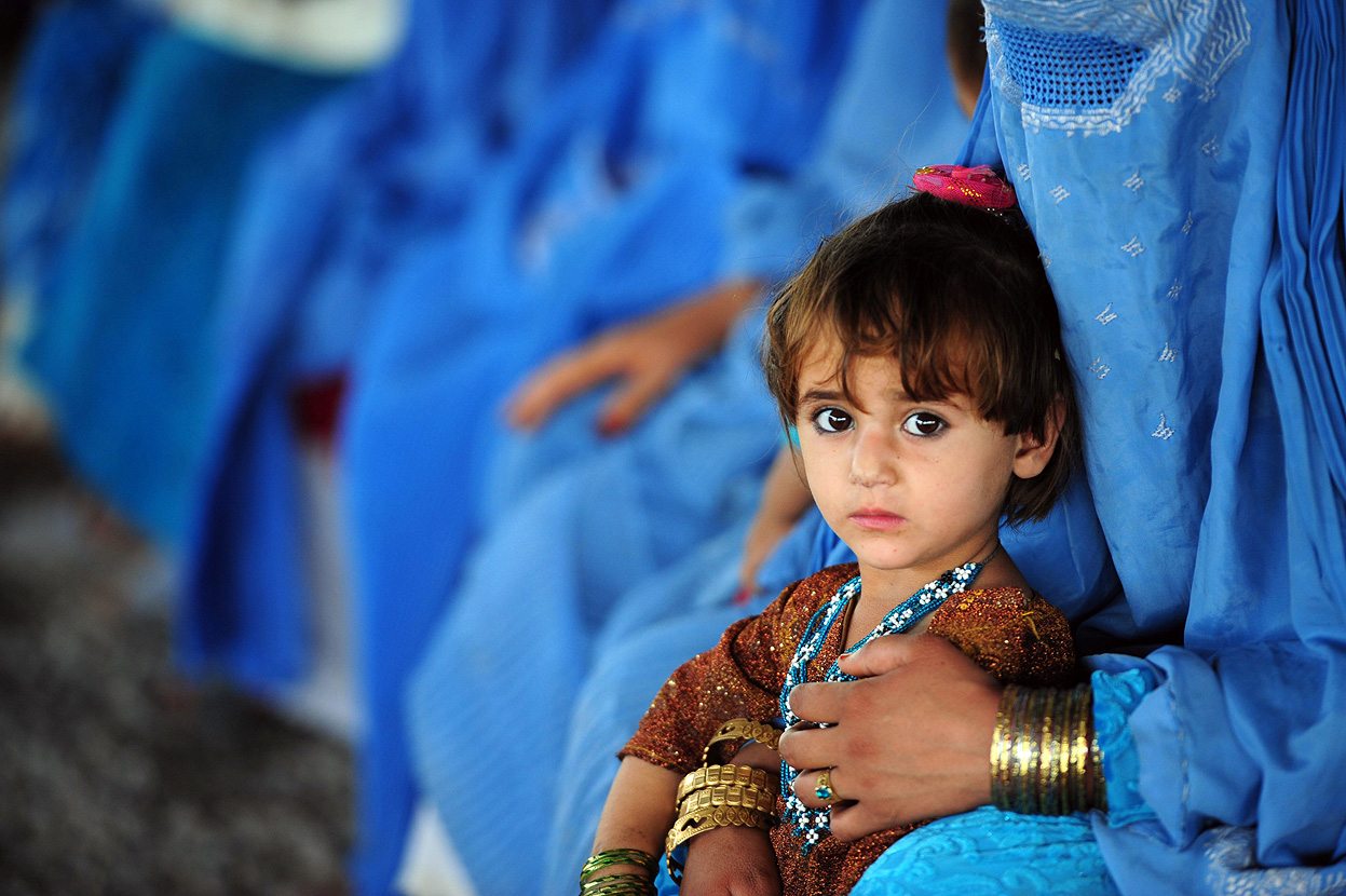 Refugee Afghan girl with her mother at the UNHCR registration center on the outskirts of Peshawar, June 2012.