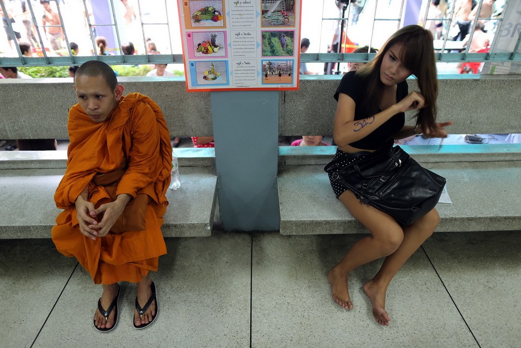Thai monk and kathoey lady-boy wait to be processed for mandatory military service.