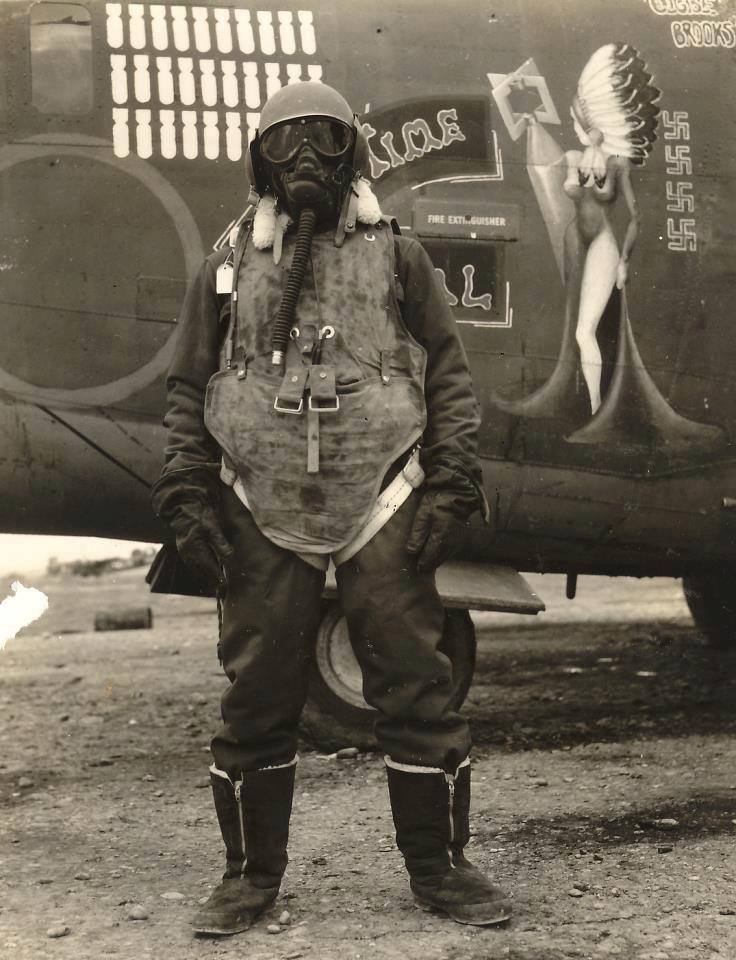 An airgunner stands before his B24 bomber wearing what it took to survive at 25,000ft over Germany in 1943-45