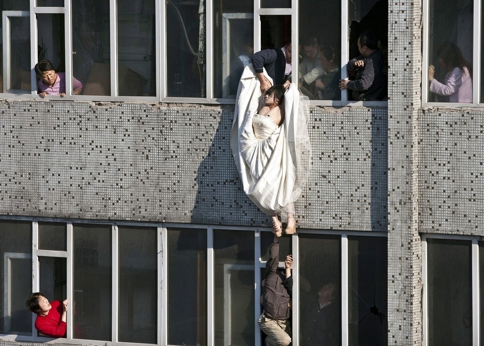A distressed bride attempts suicide in China after her fiance abruptly called off their marriage. Still in her wedding gown, she tried to kill herself by jumping out of a window of a seventh floor building. Right as she jumped, a man managed to catch and save her.