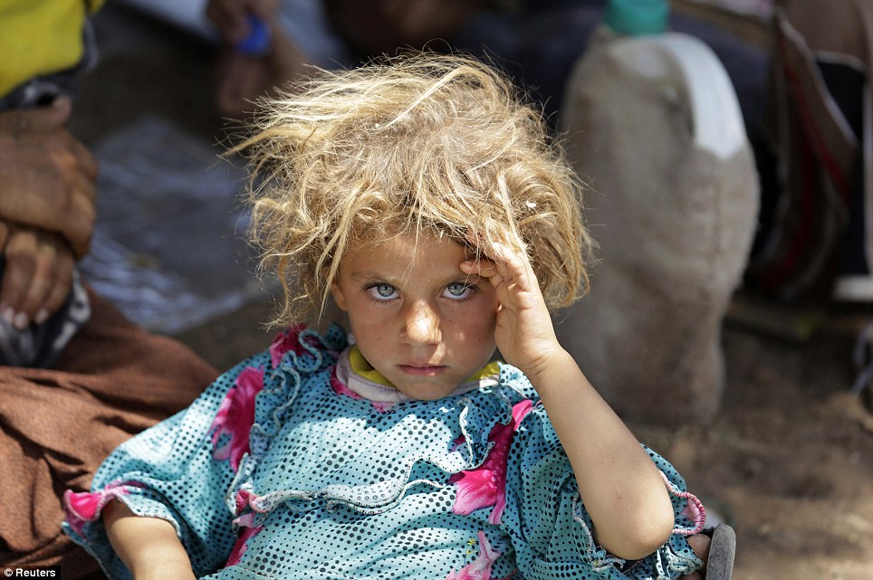 Girl from the minority Yazidi sect rests at the Iraqi-Syrian border crossing in Fishkhabour, Dohuk province after fleeing Islamic State militants