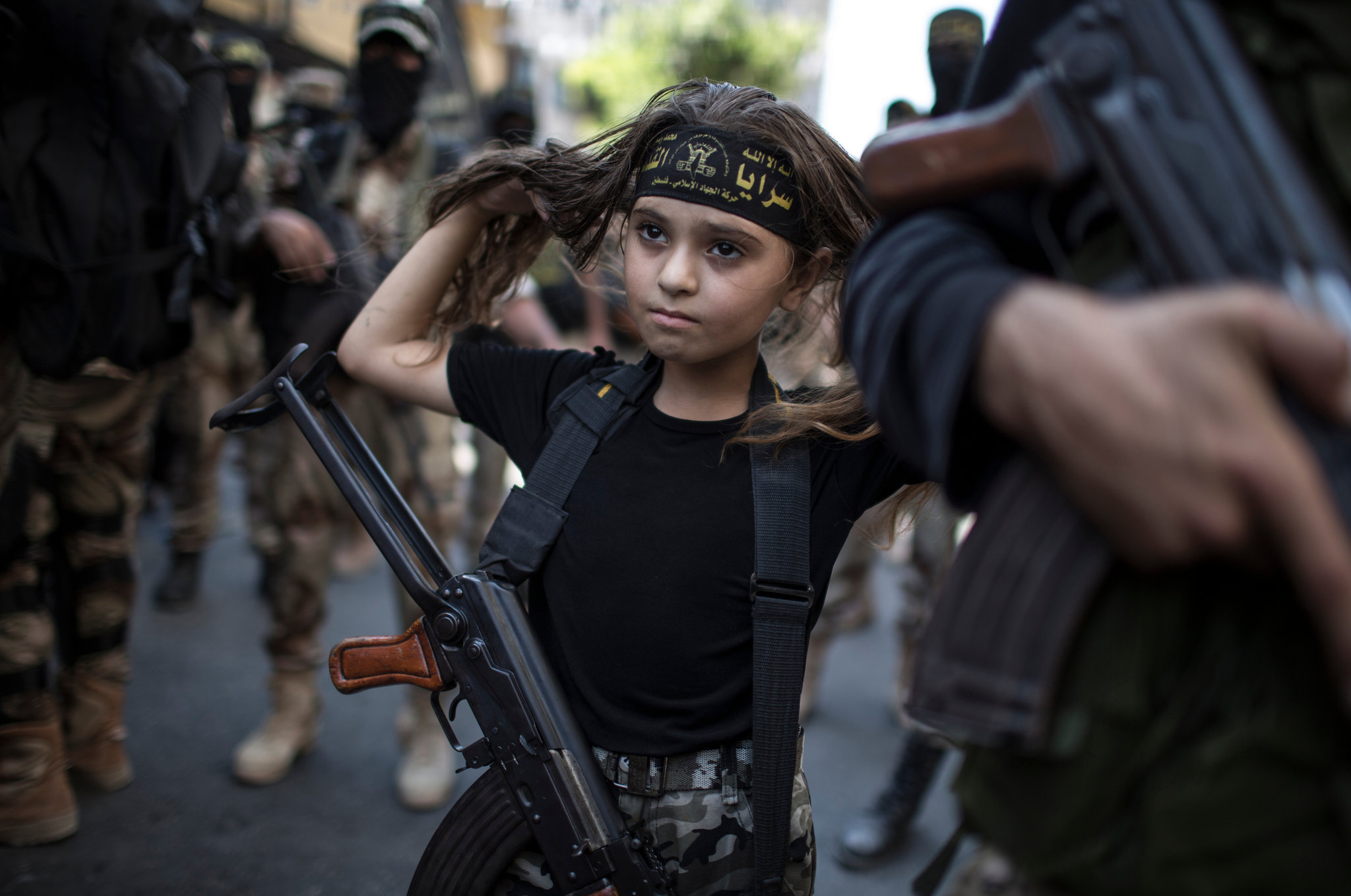 Palestinian girl with a Kalashnikov rifle, amid Islamic Jihad militants in Gaza City