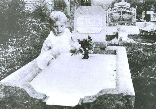 This photo was taken by Mrs. Andrews in Australia in the 1940s. When she developed the photo of her 17-year-old daughter's grave site, an image of a small child appeared in the photo.
