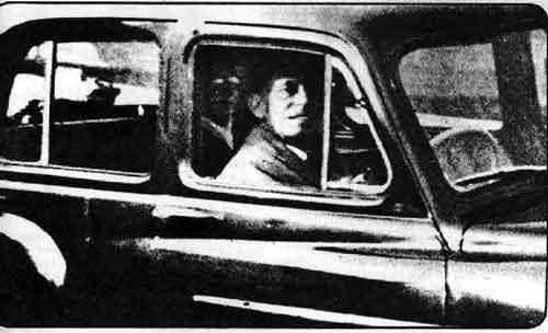 This photo was taken in 1959 by Mrs. Mabel Chinnery at the cemetery where her mother is buried. The photo clearly shows her husband sitting in the car, but there is also a mysterious man lurking in the backseat.