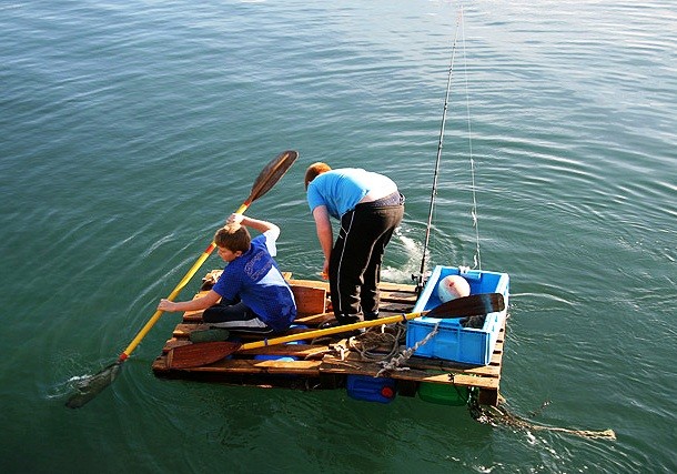 To make a temporary raft, lay out a tarp, put some lightweight material (plastic bottles, branches, bark etc.) on it, wrap the ends up and bind the entire thing with a rope. Before setting out into deep waters, make sure to test if it can hold your weight.