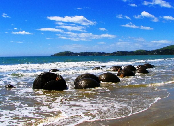 Moeraki boulders are large, spherical boulders lying along the Koekohe Beach, New Zealand. According to a local Maori legend, the boulders are the remains of eel baskets. However, modern scientific analysis shows that they consist of mud, fine silt and clay, cemented by calcite and date back to the Paleocene period (66 – 56 million years ago).