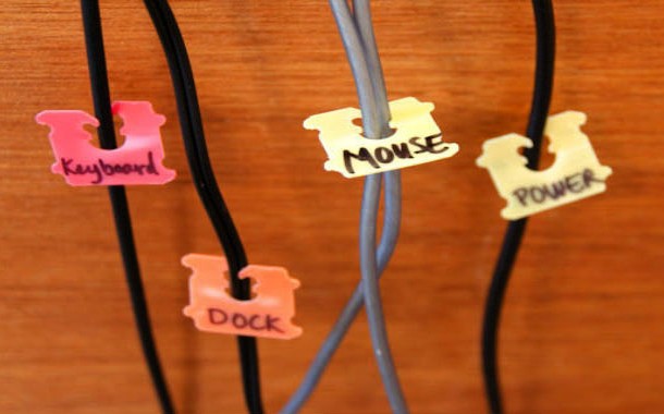 The space behind your computer is filled with a plethora of cords, most of which are exactly the same color. How can you tell them apart? How can you keep them from becoming a jumbled mess? Just label your cords by using little colored bread ties.
