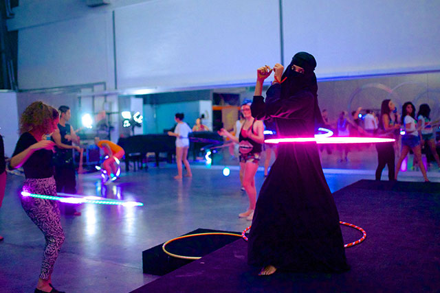 A Saudi girl hula-hooping while wearing Niqab and Abaya
