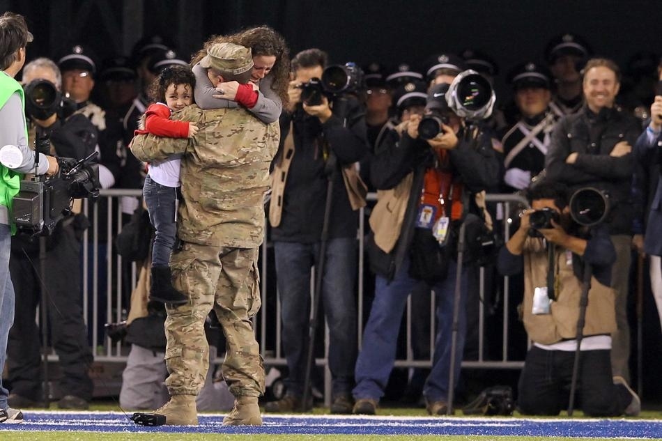 An Air Force sergeant surprises his wife and daughter during the second quarter of a game between the New York Giants and the Green Bay Packers.