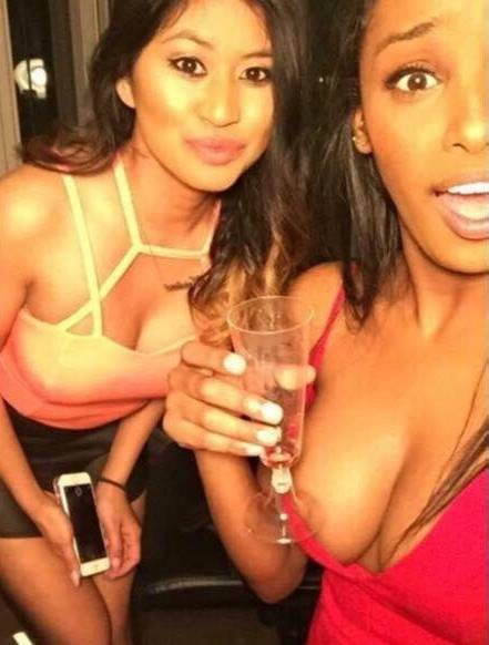 funny picture og girls posing in a night club and the girls champagne glass looks like her nipple in the photo