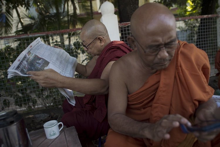 Buddhist monks attempt to find the latest news on Myanmar's first open election in 25 years. The National League for Democracy is expected to win, ending decades of military rule