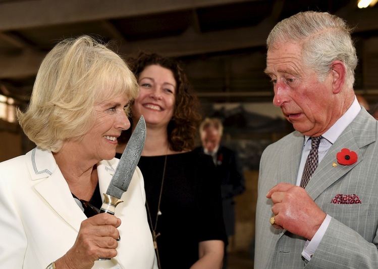 Britain's Prince Charles watches on as Camilla, Duchess of Cornwall, holds a knife during a vist to a winery South Australia's Barossa Valley.