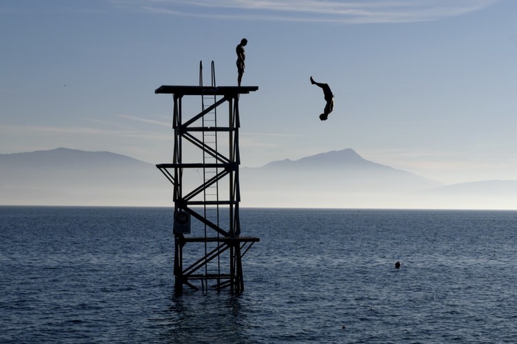 A man dives into Lake Geneva as unusually warm weather briefly hit Switzerland.