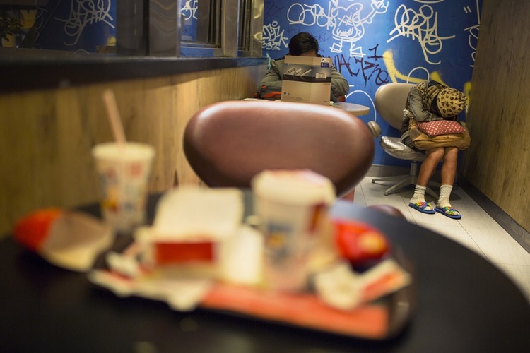 A woman sleeps at a 24-hour McDonald's in Hong Kong, where house prices are so high that many are 'McRefugees.'