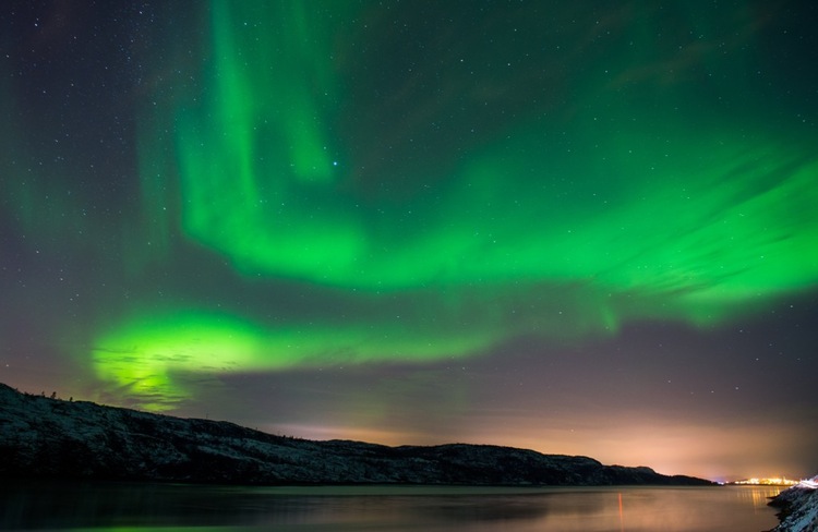 The Northern Lights illuminate the sky above the town of Kirkenes, Norway.
