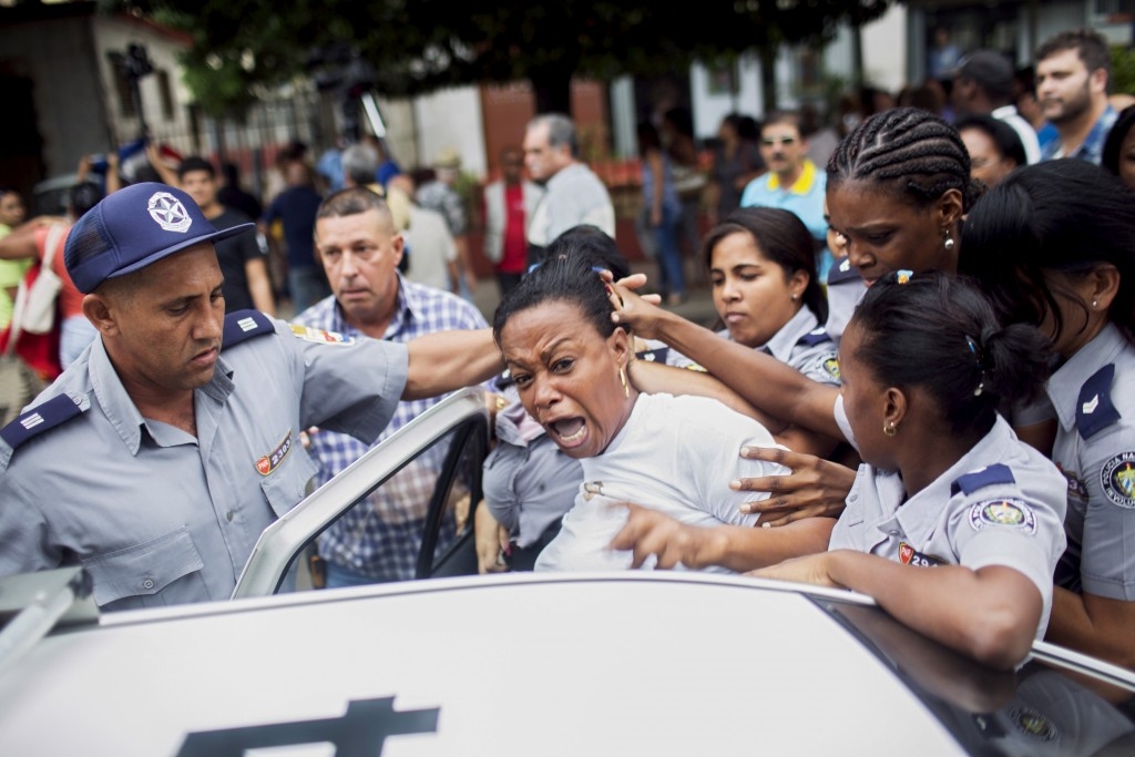 Cuban security personnel detain a member of the Ladies in White during a protest on International Human Rights Day, Havana.