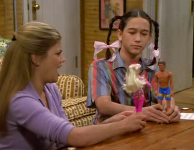 Joseph Gordon-Levitt with pigtails playing with action figures in a shirt probably made from his grandparents’ couch: