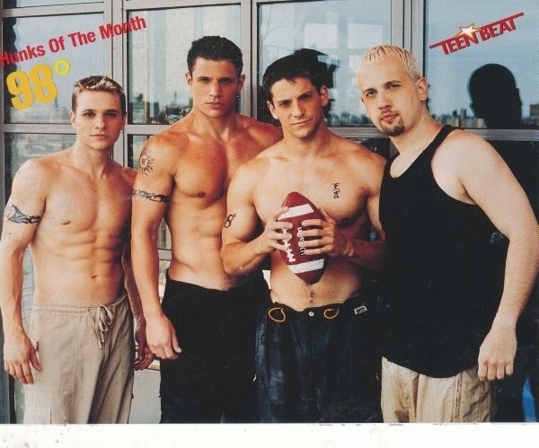 98 Degrees getting ready to play football inside a department store with one of those guys who probably goes swimming with a shirt on: