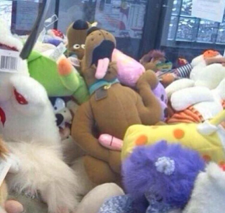 Funny picture of stuffed animal dog that looks like he might be jerking off in the pile of toys