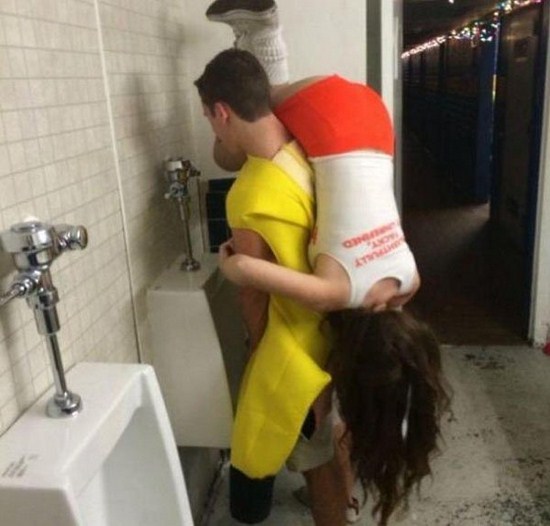 man holding a girl while he pees