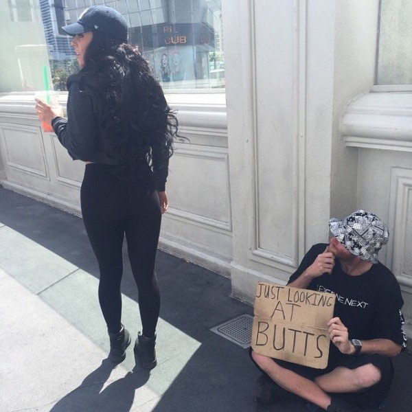 Man with sign that he isn't begging, just enjoys looking at butts