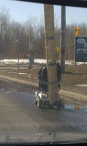 Funny picture of man in motorized wheelchair and a large plank of wood.