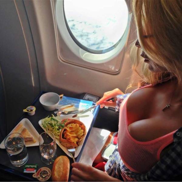 Woman on an airplane eating her food.