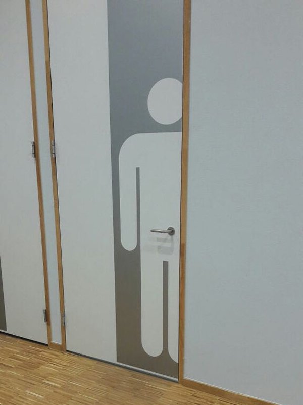 Funny picture of a men's room door that has a door-handle that is in the absolute worst positioning.