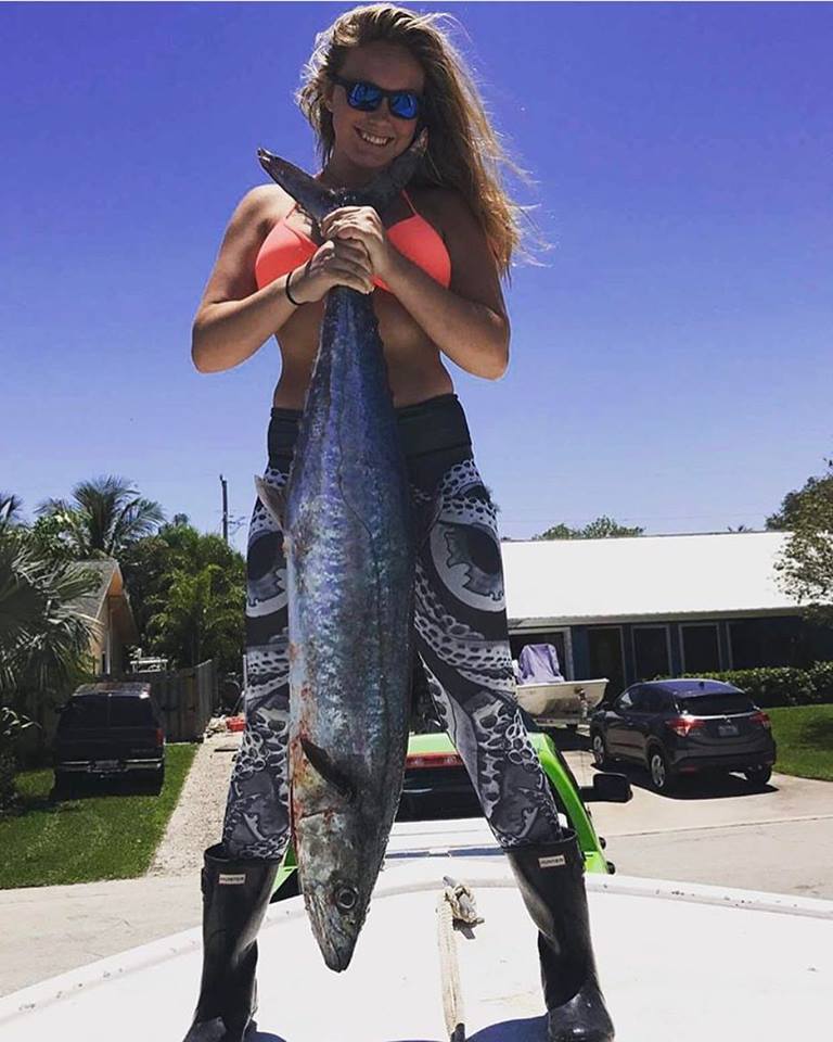 Girl holding up a very large fish.