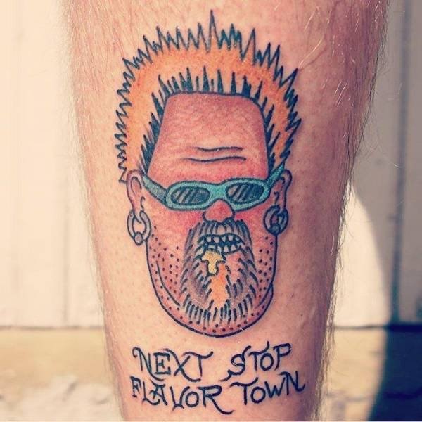 Tattoo of weird face and words NEXT STOP FLAVOR TOWN
