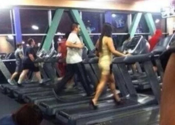Woman power walking on a treadmill in mini-dress and high heels