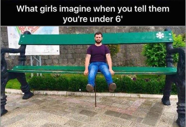 Guy sitting on a large bench captioned that is how girls imagine it when you say you are under six feet tall.