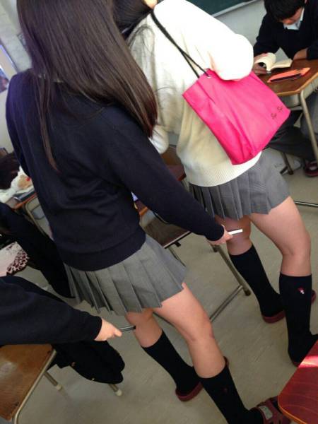 Girl taking an upskirt picture of another girl.