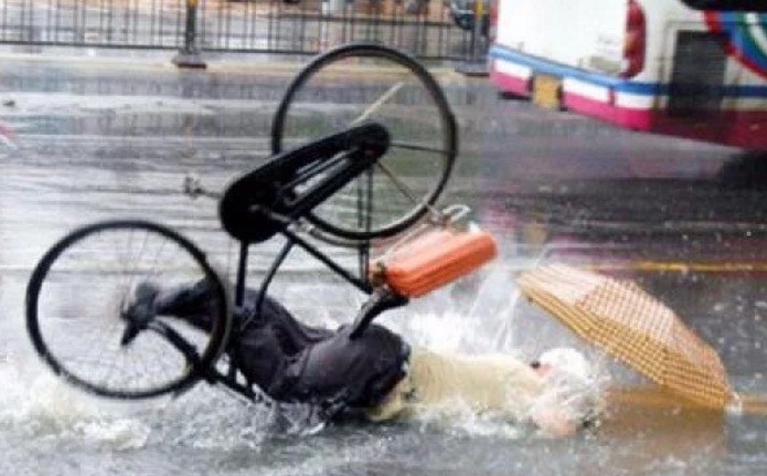Person riding on a bicycle in the rain that is face planting in the most painful way possible