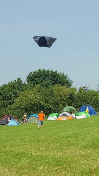 Man running after his tent which is flying away