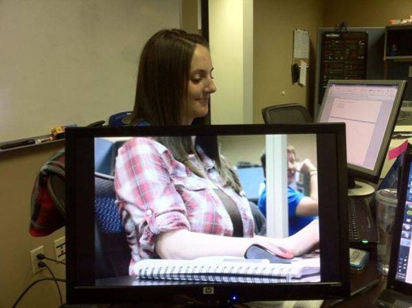 Girl at the office perfect timing with image on the screen in front of her.