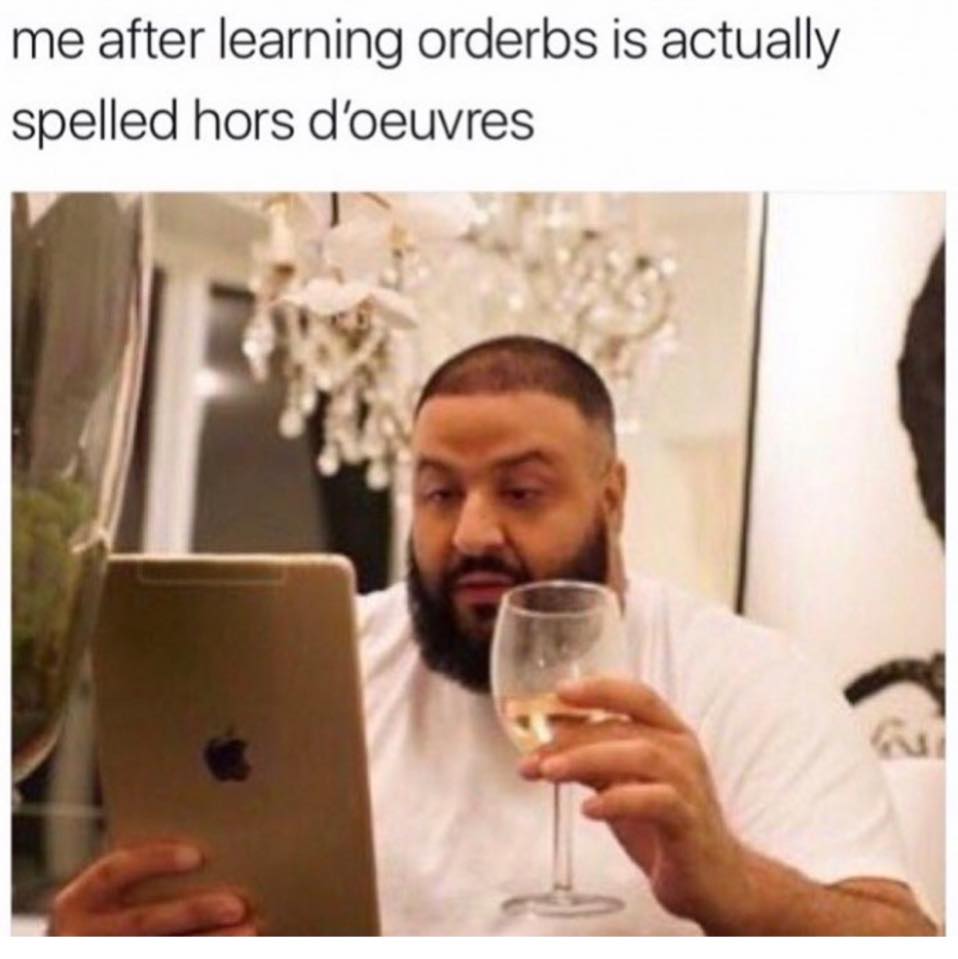 Meme about learning how Hors D'oeuvres is spelled showing DJ Khaled drinking a glass of wine and reading something interesting on his iPad.