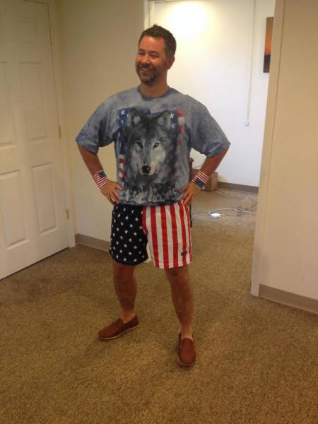 Man wearing shirt of a flag and wolf and shorts made out of the American flag.