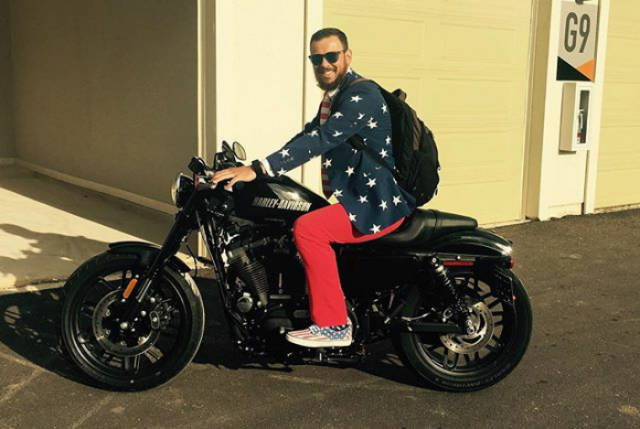 Man wearing red, white, and blue on a motorcycle.