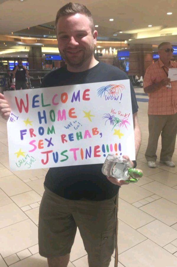 guy holding gag sign at the airport