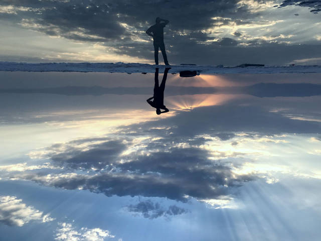 Standing on a reflective pool