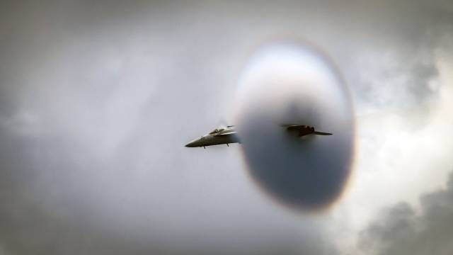Airplane going through sonic boom cloud