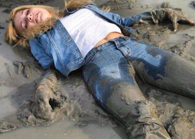 Hot woman roiling around in the mud while fully clothed.