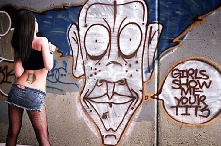 Graffiti face telling girls to flash with girl flashing him, backto the camera