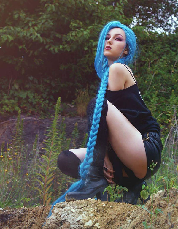 Girl with blue hair braid standing up on a rock
