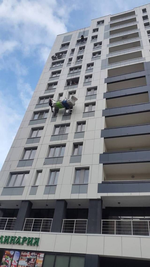 Man climbing a building when there is a lift right under him.