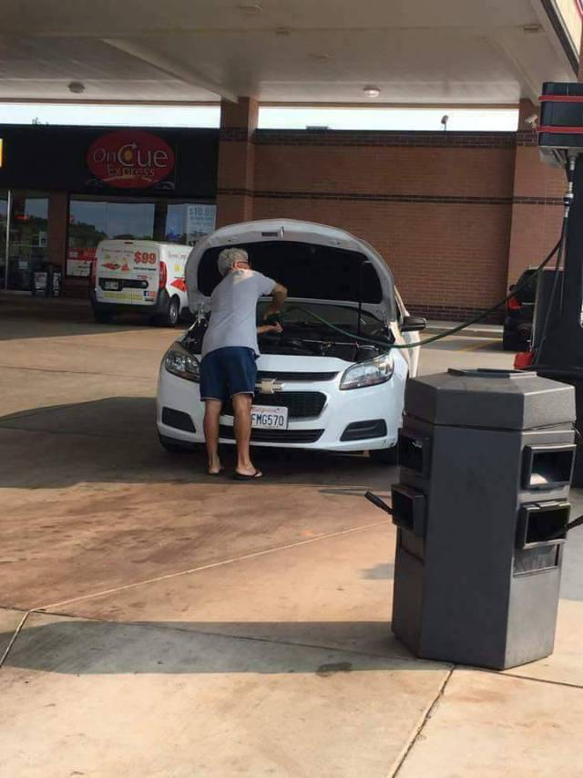 Man filling up his engine with gas. WTF