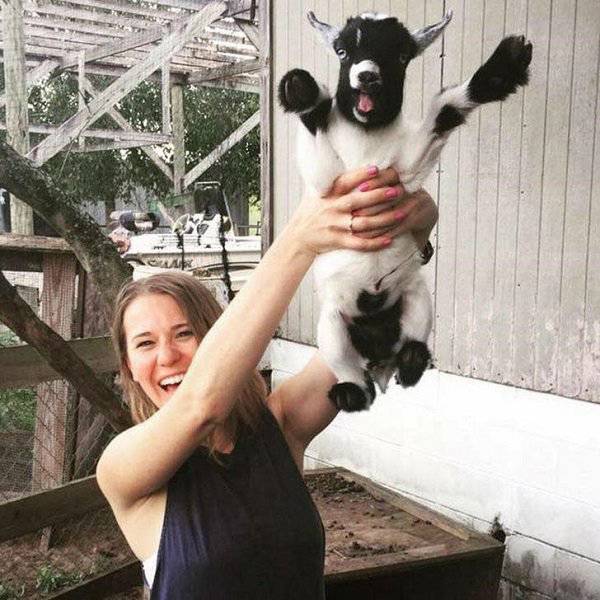 Woman holding up a baby goat